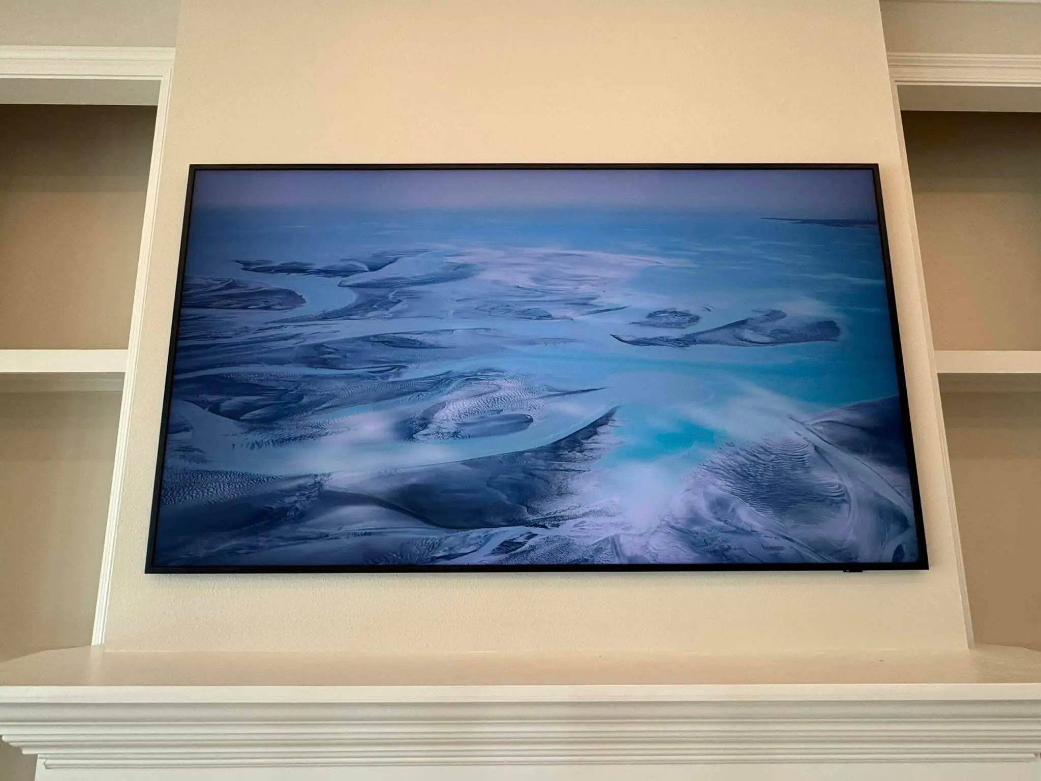Wall-mounted television on a gray shiplap wall.