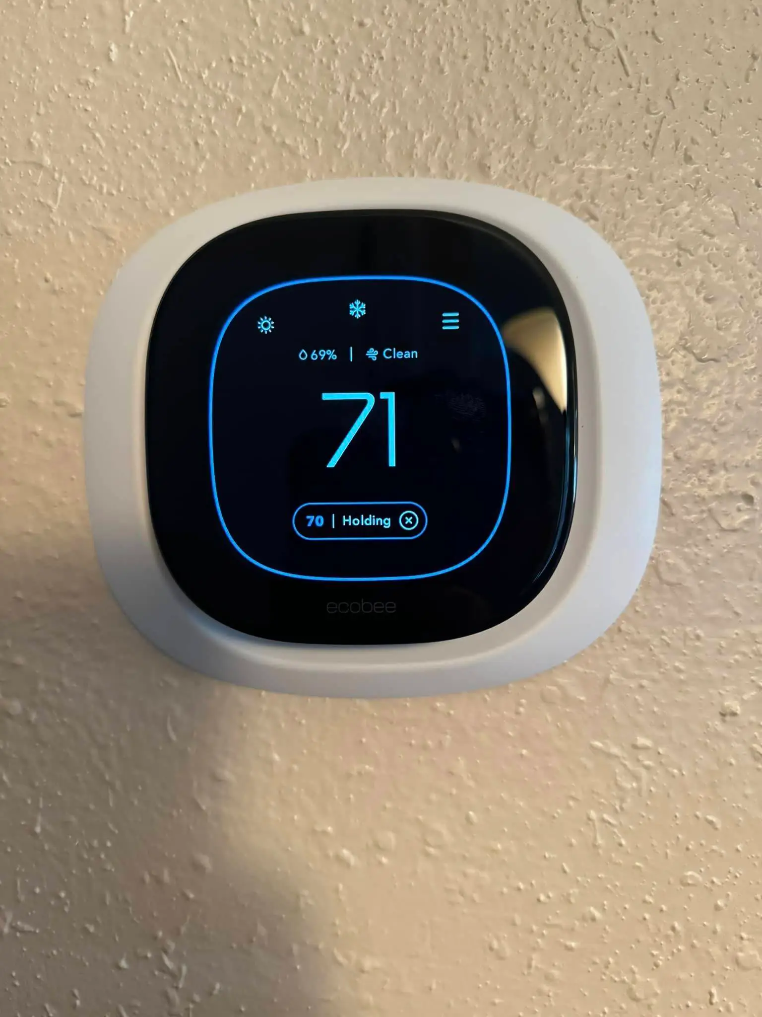 Smart-home camera, keypad, or screen on the Westbank: interior tall photo, warm light, even light across the frame.