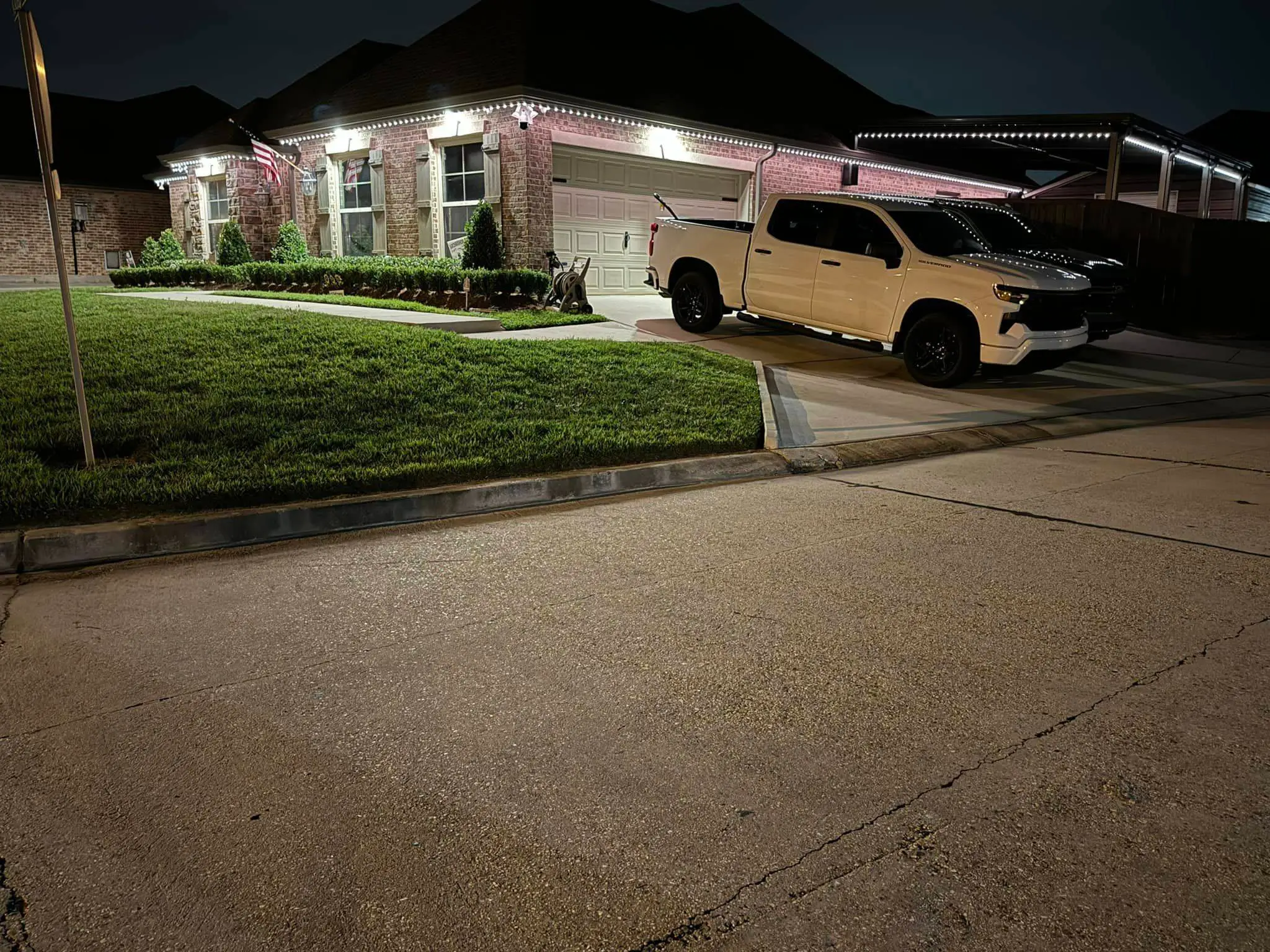 Downlights on a Westbank house, installed with Trimlight: night wide photo, warm light, brighter toward the bottom.