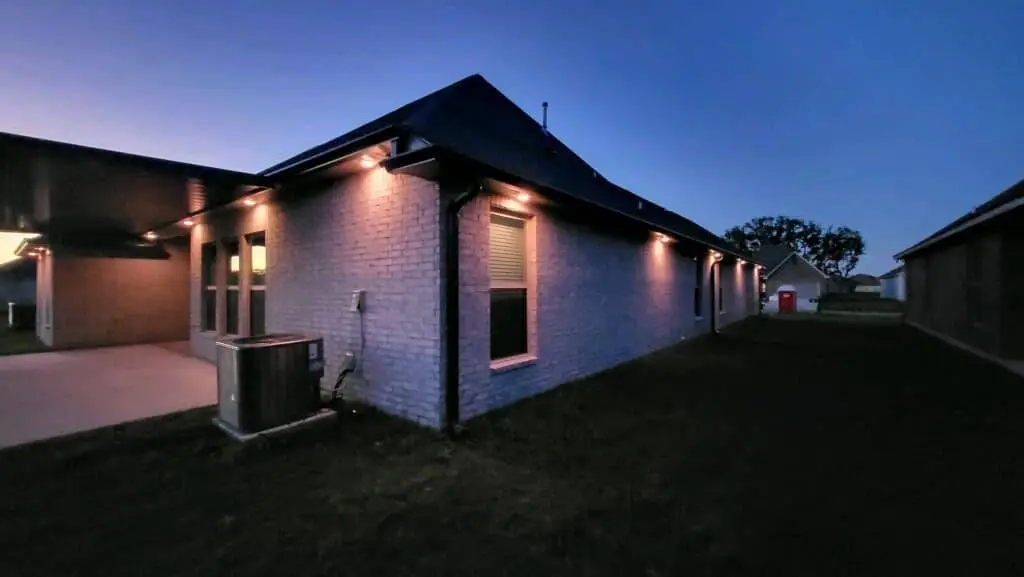 Downlights on a Westbank house, installed with Trimlight: night wide photo, blue light, brighter toward the top.